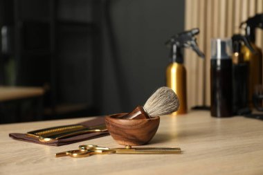 Berber dükkanında, açık ahşap masada birçok farklı berber aletleri var.