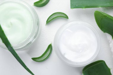 Aloe vera özütüyle nemlendirici krem ve beyaz desenli arka planda yapraklar.
