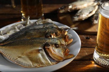 Kurutulmuş balık ve bira bardakları ahşap masada, yakın plan.