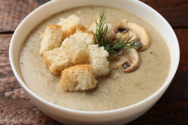 Ekmek arası mantar kremalı çorba ve ahşap masada dereotu, yakın plan.