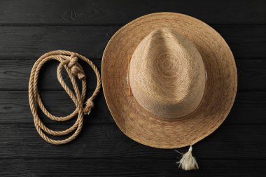 Siyah ahşap zemin üzerinde pamuk ip ve hasır şapka, düz yatıyordu.