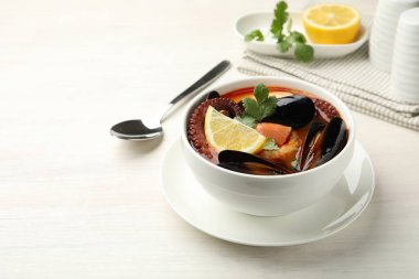 Hafif ahşap masada servis edilen lezzetli deniz ürünleri çorbası.