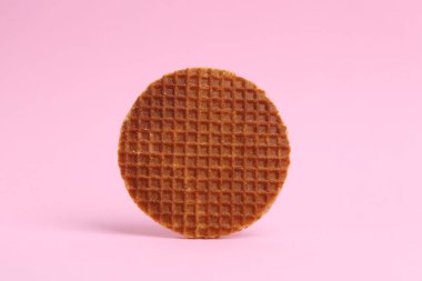 Pembe arka planda lezzetli yuvarlak bir waffle.