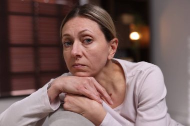 Akşamları evdeki koltukta depresif bir kadın.