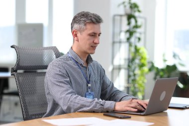 Ofisteki masada dizüstü bilgisayarla çalışan mühendis.