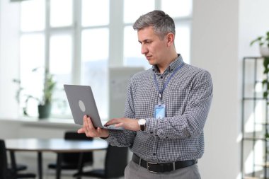 Ofiste dizüstü bilgisayarla çalışan profesyonel bir mühendis.