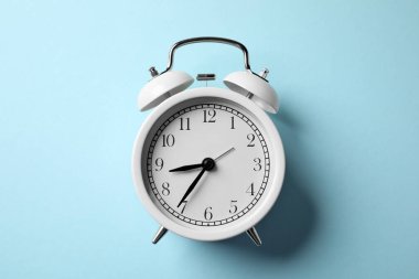 Açık mavi arkaplanda beyaz alarm saati, üst görünüm