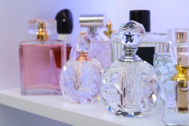 Dükkandaki raflarda farklı lüks parfüm şişeleri var.