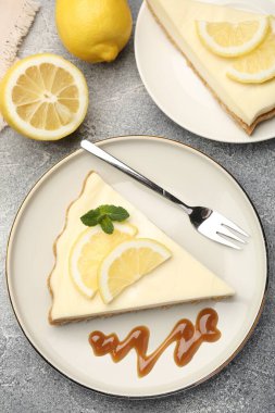 Lezzetli limonlu cheesecake parçaları gri desenli masada servis ediliyor.