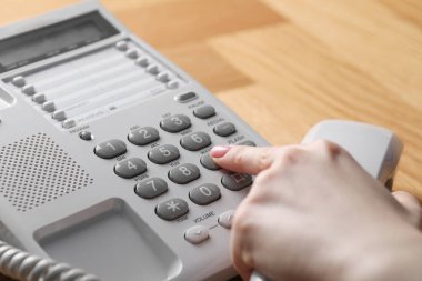 Ahşap masada telefonla arayan kadın, yakın plan.