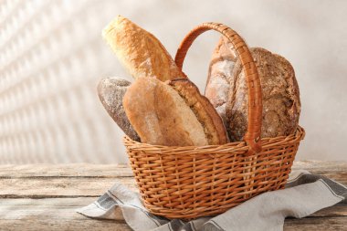 Tahta masadaki sepetin içinde farklı somunlar, yakın çekim.