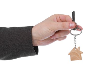 Beyaz arka planda ev şekilli anahtarlığı olan bir emlakçı. Yakın plan.