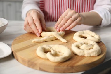 Mutfaktaki masada simit şekillendiren kadın, yakın plan.