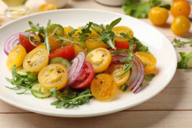 Beyaz ahşap masada sarı domatesli taze salata, yakın plan.