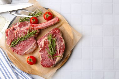 Çiğ sığır eti, biberiye ve domates parçaları beyaz fayanslı masa, düz yatak. Metin için boşluk