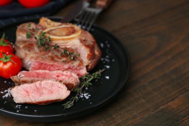 Lezzetli et parçaları, ahşap masada baharatlar ve domatesler, yakın plan. Metin için boşluk