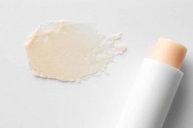 Dudak kremi ve örnek beyaz arka planda, üst görünümde.