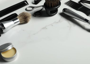 Beyaz mermer masadaki birçok farklı berber aletinden yapılmış çerçeve, yakın plan. Metin için boşluk