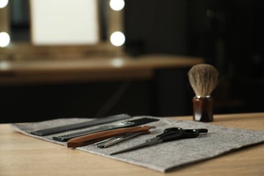 Berber dükkanında, açık ahşap masanın üzerinde birçok farklı berber aleti var.