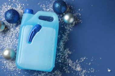 Plastik kapta antifriz, takılar ve mavi arka planda buz, düz bir zemin. Metin için boşluk