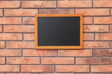 Tuğla duvarda boş küçük bir tahta.