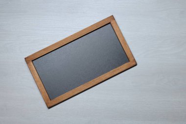 Hafif ahşap zemin üzerinde boş küçük karatahta, üst görünüm