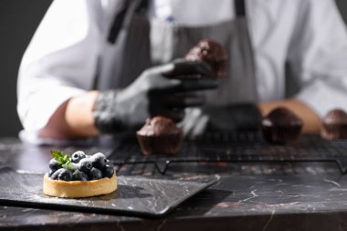 Koyu masada çikolatalı kekle şekerci, tarta odaklan.