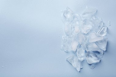 Açık mavi arka planda ezilmiş buz parçaları, üst manzara. Metin için boşluk