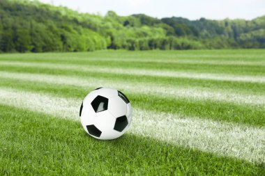 Futbol sahasında futbol topu ve açık havada işaretler.