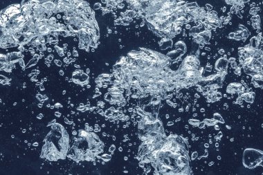 Koyu mavi arka planda köpüklü soda, yakın plan.