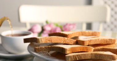 Lezzetli kızarmış ekmek masada dönüyor. Fincana çay dök, yakın çekim.