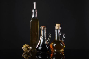 Aynada salata sosları ve zeytinler siyah arka planda