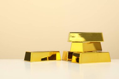 Bej arka planda parlak altın külçeler, yakın plan. Metin için boşluk