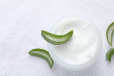 Aloe vera özütüyle nemlendirici krem ve beyaz havluyla kesilen yapraklar.