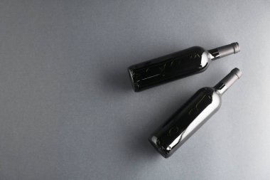 Gri arka planda şarap şişeleri, düz yatış. Metin için boşluk