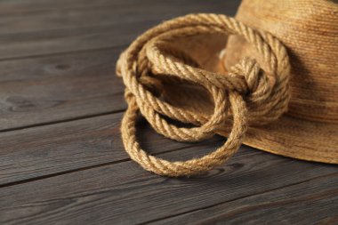 Ahşap arka planda pamuk ip ve hasır şapka, yakın plan.