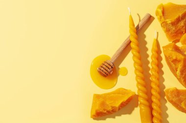 Güzel balmumu mumlar, ballı cips ve bej arka planda balmumu parçaları, düz yatak. Metin için boşluk