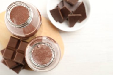 Lezzetli çikolatalı süt ve parçalar beyaz masada, düz yatıyordu.