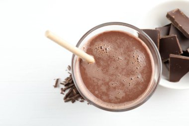 Lezzetli çikolatalı süt, talaş ve beyaz masa, üst manzara.