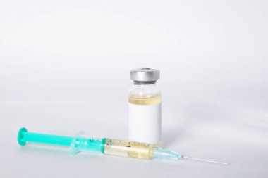 Cam şişede Hepatit aşısı ve arka planda şırınga, yakın plan.