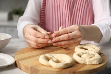 Mutfaktaki masada simit şekillendiren kadın, yakın plan.
