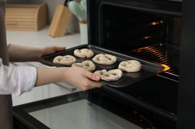 Pişmemiş krakerlerle fırına yemek koyan kadın, yakın plan.