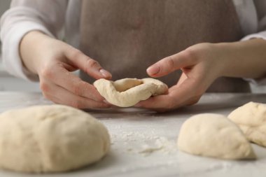 Mutfaktaki masada simit şekillendiren kadın, yakın plan.