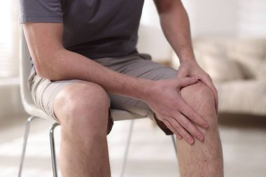 Evinde diz ağrısı çeken bir adam, yakın plan.