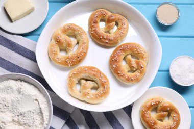 Lezzetli krakerler ve malzemeler açık mavi ahşap masada, düz yerde.