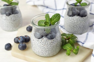 Yaban mersinli Chia pudingi ve ışıklı masada nane şekeri.