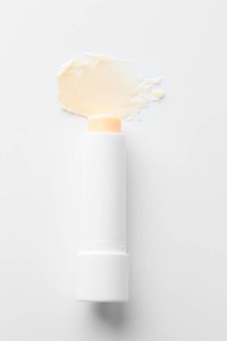 Dudak kremi ve örnek beyaz arka planda, üst görünümde.