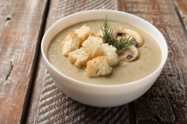 Ekmek arası mantar kremalı çorba ve ahşap masada dereotu, yakın plan.