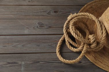 Ahşap arka planda pamuk ip ve hasır şapka, yakın plan. Metin için boşluk