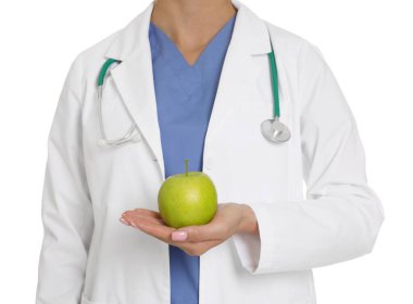 Beyaz arka planda yeşil elmalı ve steteskoplu beslenme uzmanı, yakın plan.